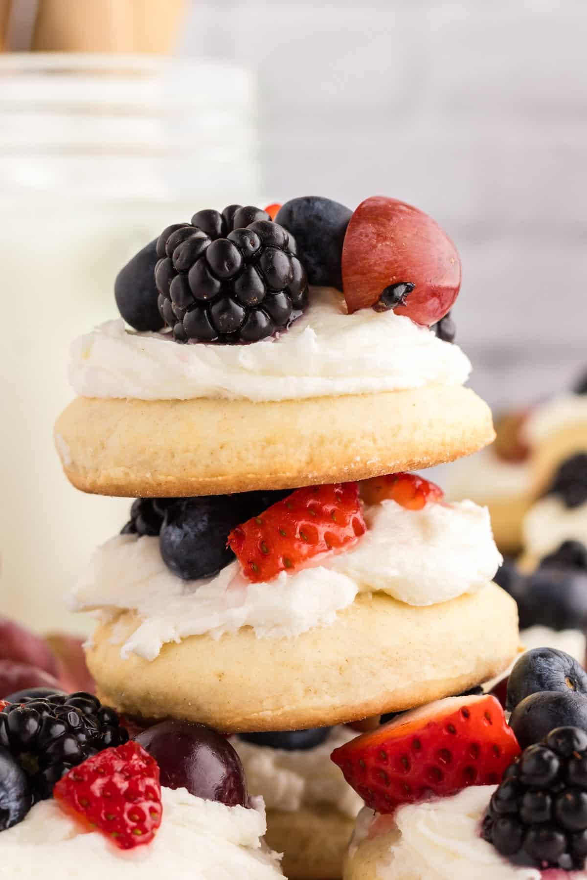 Μπισκότα Ζάχαρης Φρουτοπίζα 10 leaning stack of fruit pizza cookies with fresh fruit all around.