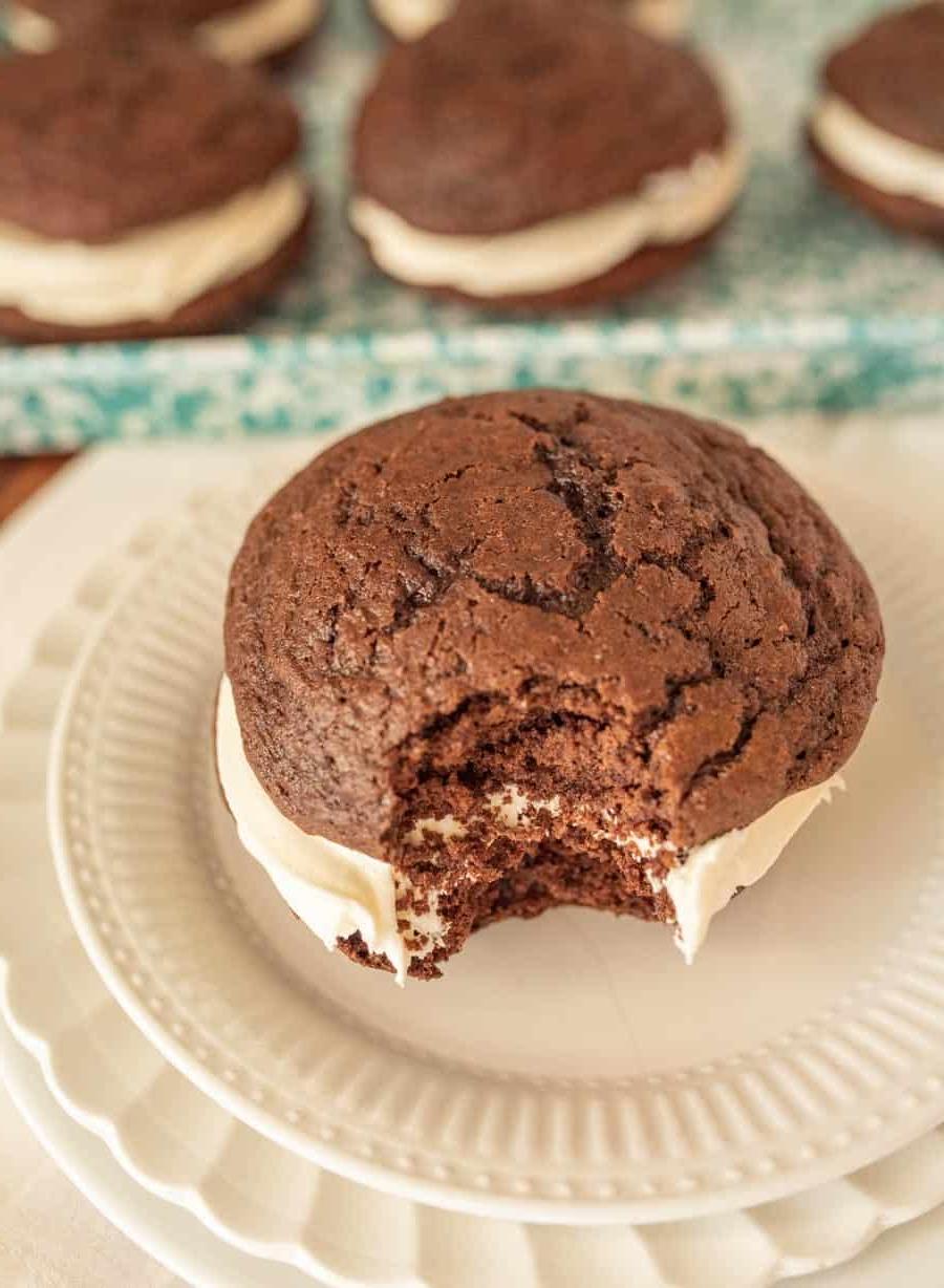 Γούπι Πάις 3 Κοντινή όψη ενός Whoopie Pie με μία μπουκιά να λείπει, σε ένα λευκό πιάτο.