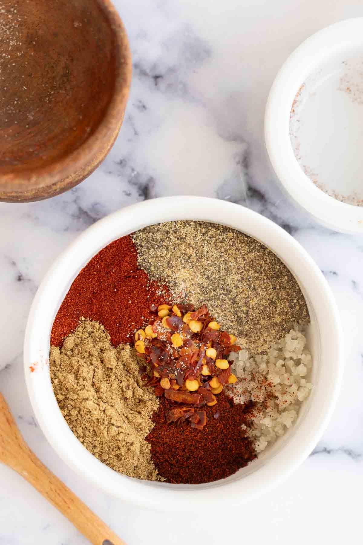 Καρύκευμα Αντόμπο 6 small dish with all of the adobo seasoning ingredients not yet mixed