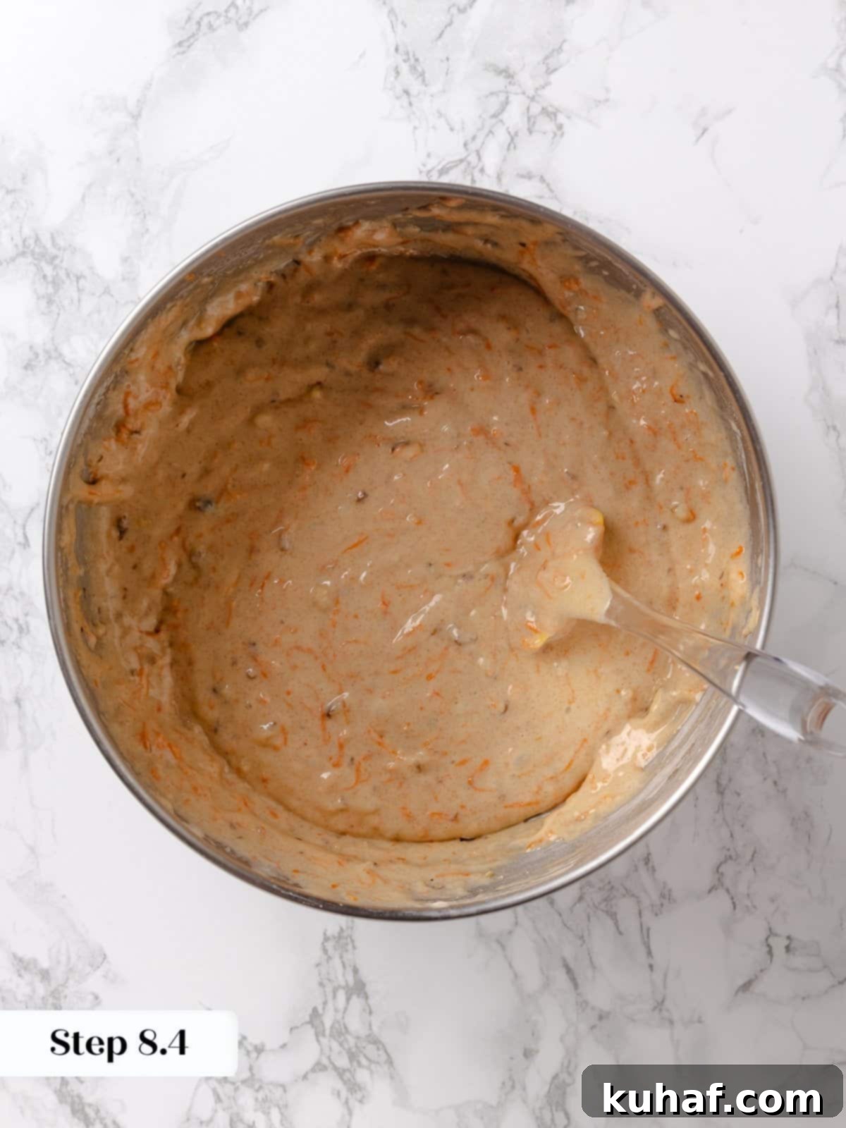 Mixed cake batter in a bowl before pouring into pans, showing a rich, chunky texture.