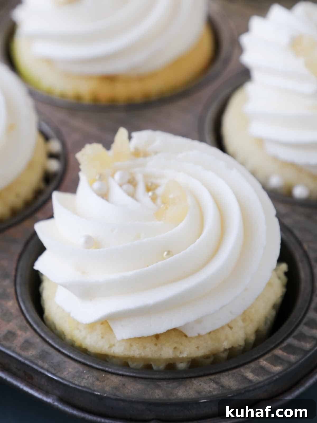 Piped lemon buttercream frosting on cupcakes, showcasing its smooth texture and light color.
