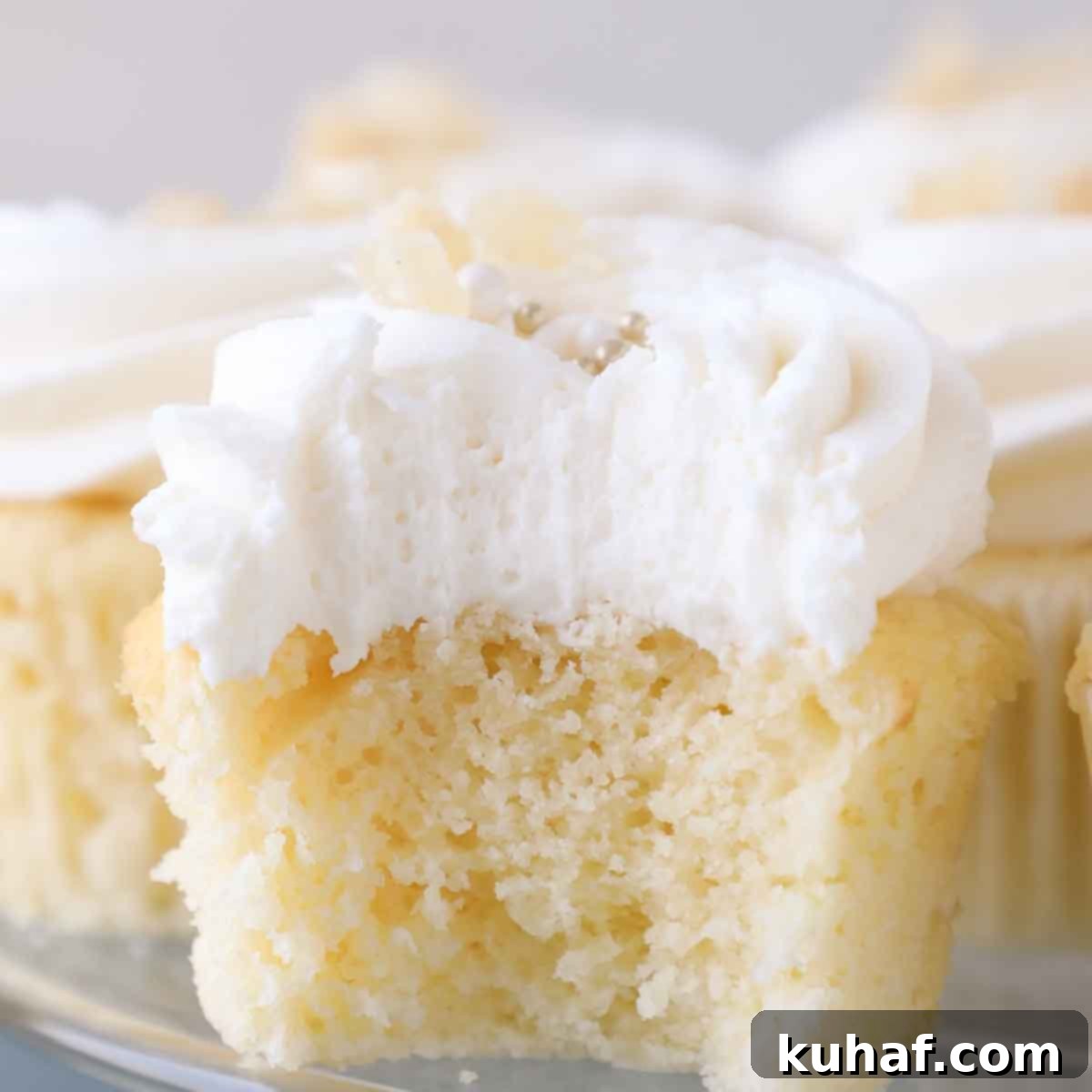 The fluffy interior texture of lemon buttercream frosting on a cupcake.
