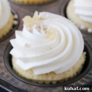 piped lemon buttercream frosting on cupcakes in tin.