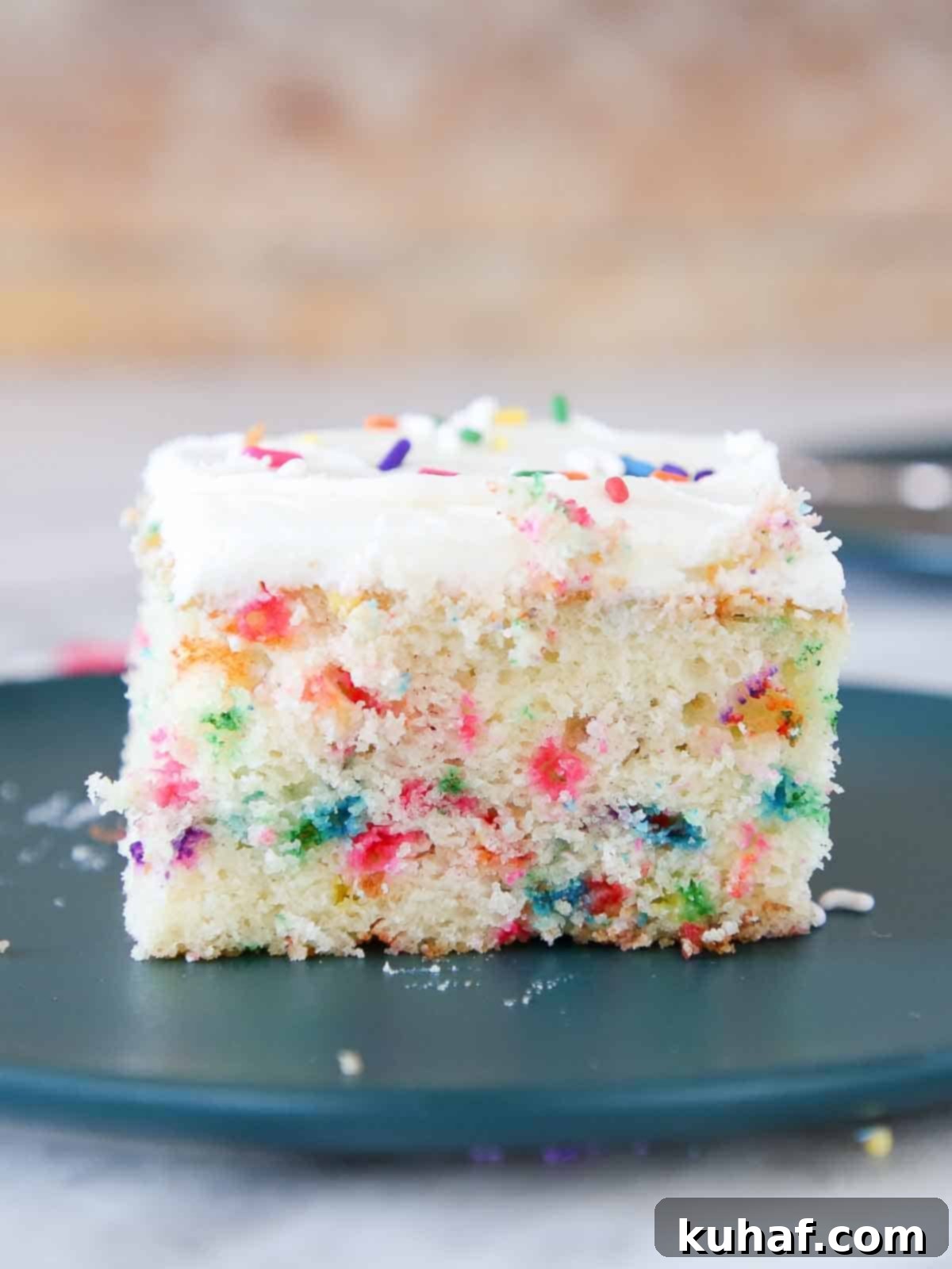 A vibrant slice of homemade Funfetti cake showing its moist texture and colorful sprinkles.