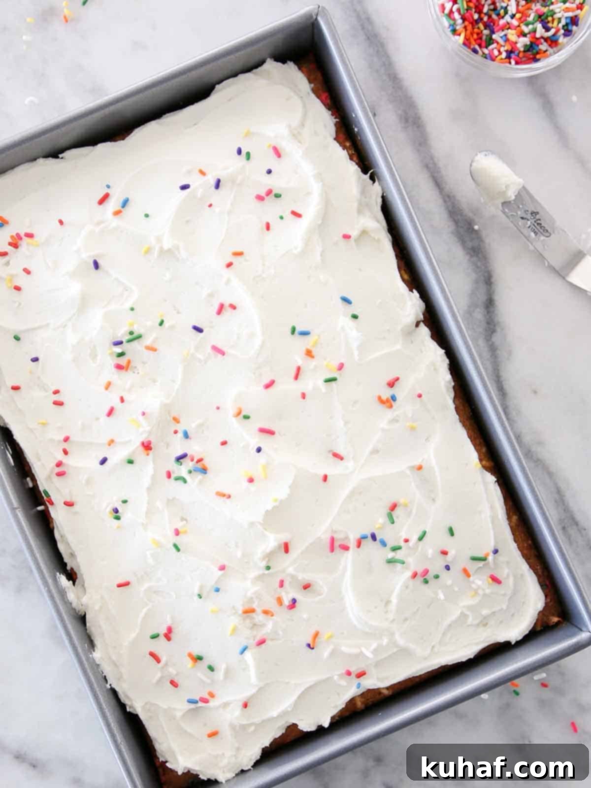Funfetti sheet cake generously iced with bright lemon buttercream in a 9x13 inch pan.
