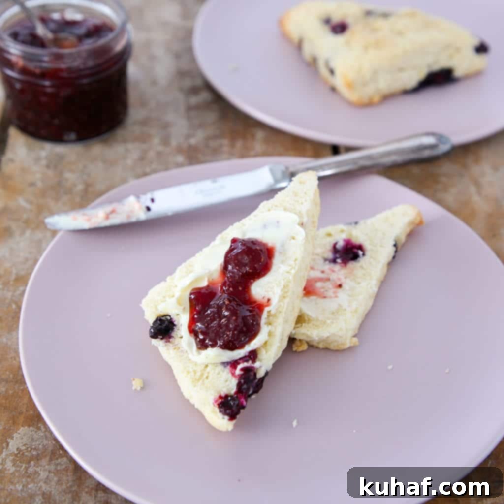 Close-up of a stack of golden-brown blueberry scones, showcasing their moist interior and pockets of blueberries.