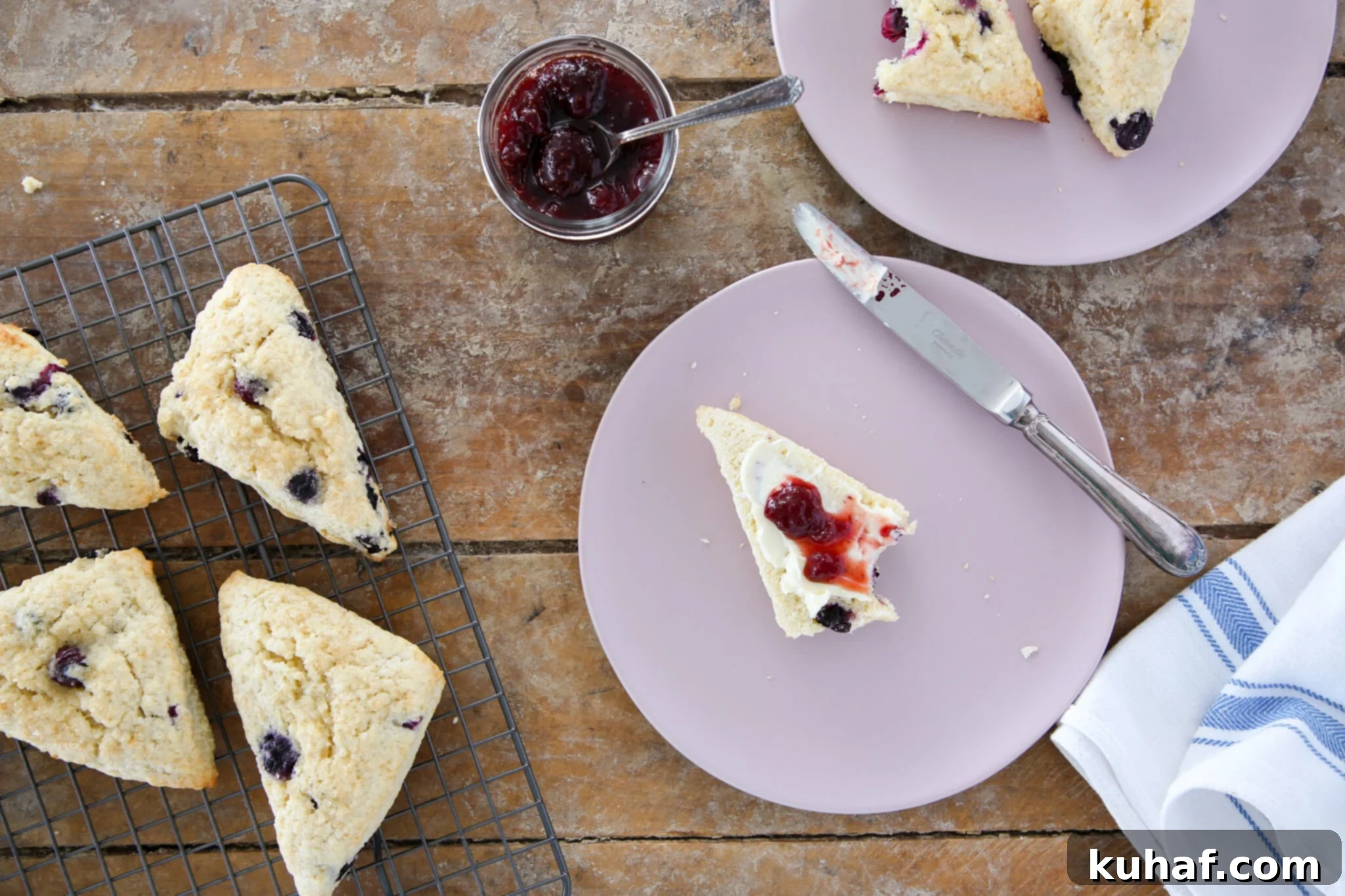 A tray of unbaked blueberry scones, brushed with cream and sprinkled with turbinado sugar, ready for the oven.
