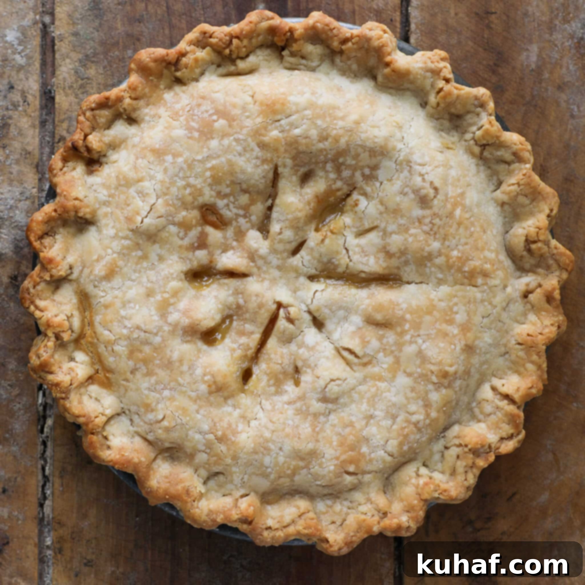 Old Fashioned Peach Pie unsliced baked on wooden surface.