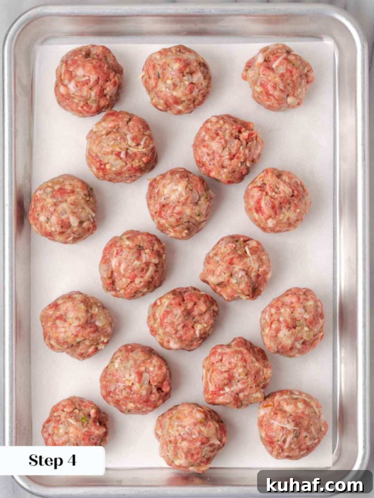 Fluffy Ricotta Meatballs 8 rolled raw meatballs on sheetpan.