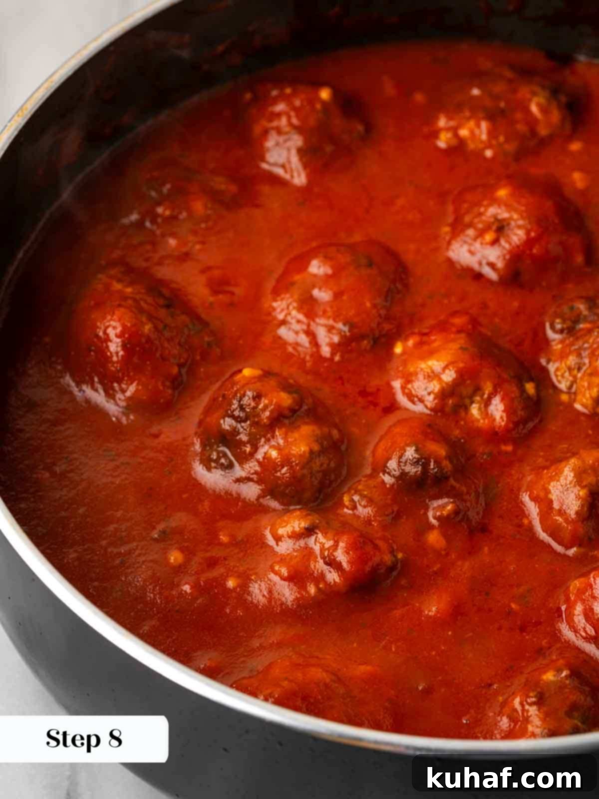 Fluffy Ricotta Meatballs 10 meatballs cooking in red sauce.