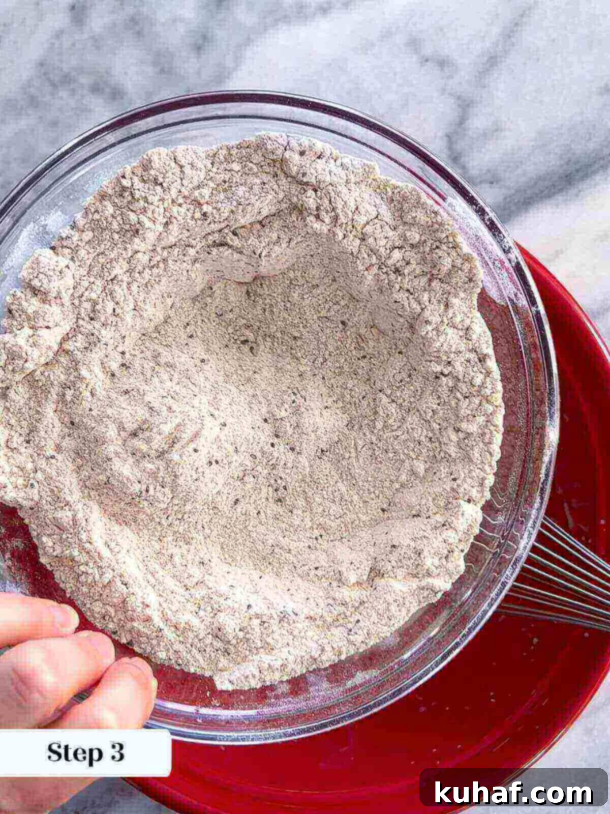 Delicious Strawberry Muffins 4 A close-up view of dry ingredients, including flours, salt, baking soda, baking powder, and chia seeds, being mixed in a bowl for strawberry muffins.