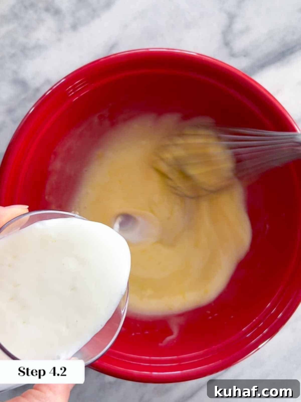 Delicious Strawberry Muffins 6 Buttermilk being poured into a mixing bowl with other wet ingredients, contributing to the moistness of the muffin batter.