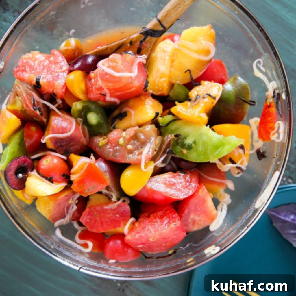 Marinated Tomato Stone Fruit Salad ingredients in a bowl before tossing