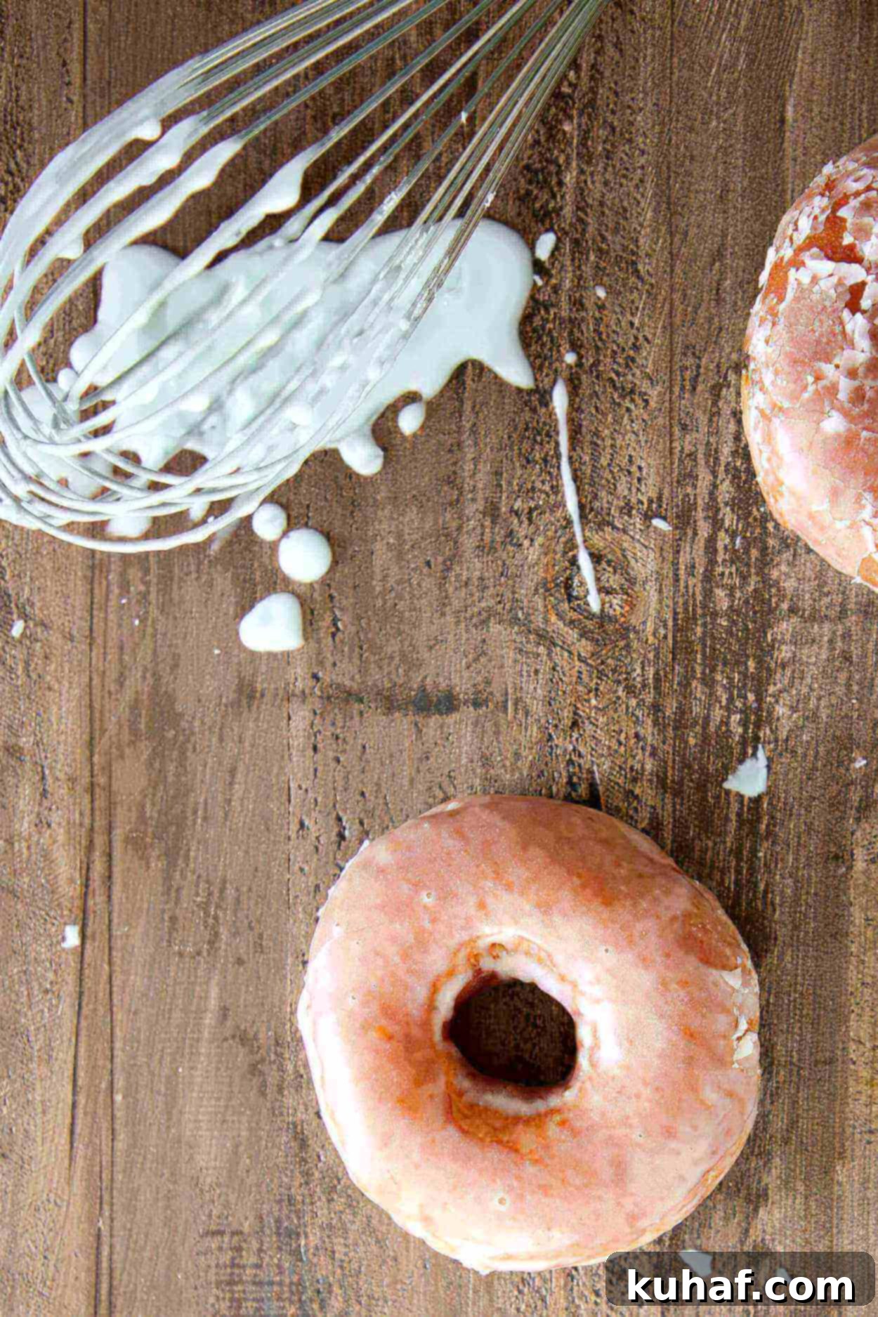 Irresistible Donut Glaze 2 A perfectly dripped classic donut glaze off a whisk onto a dark wood slate background, showcasing its glossy texture and ideal consistency. This image highlights the key characteristic of a thin, sweet glaze that dries with a perfect crackle.