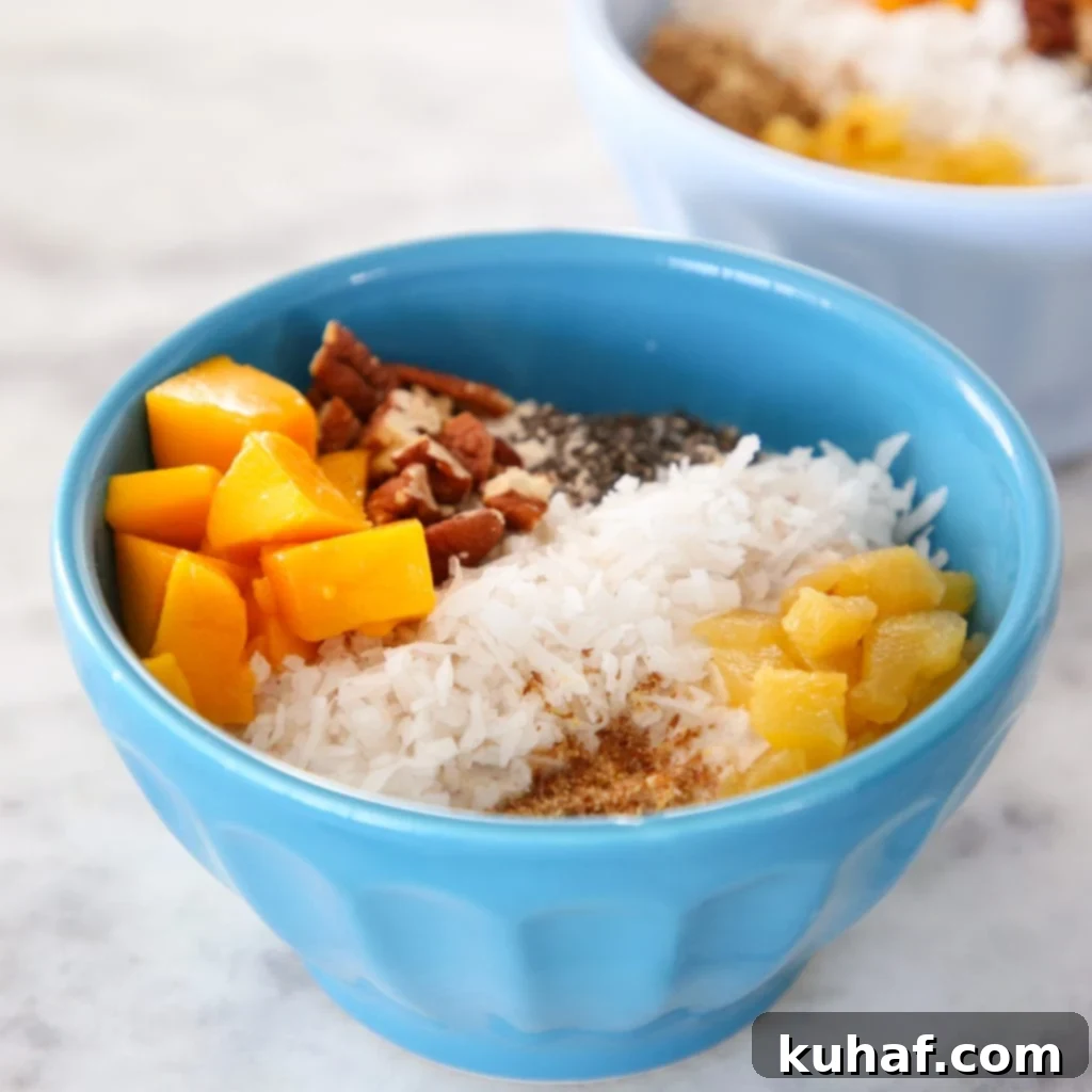 Tropical Overnight Oats in a bowl, garnished with fresh fruits.