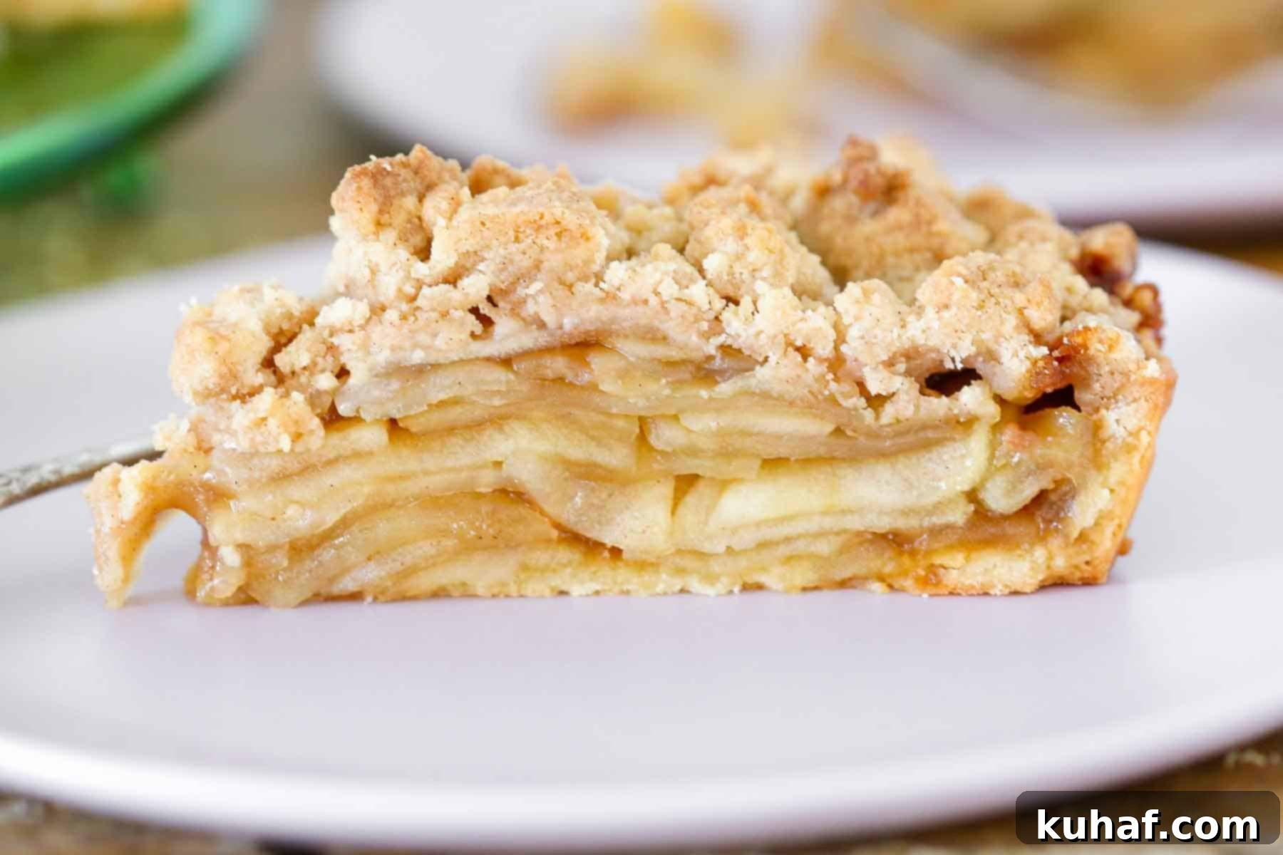 A beautifully baked caramel apple tart with a Pâte Sucrée crust, viewed from the side to showcase its golden-brown perfection.