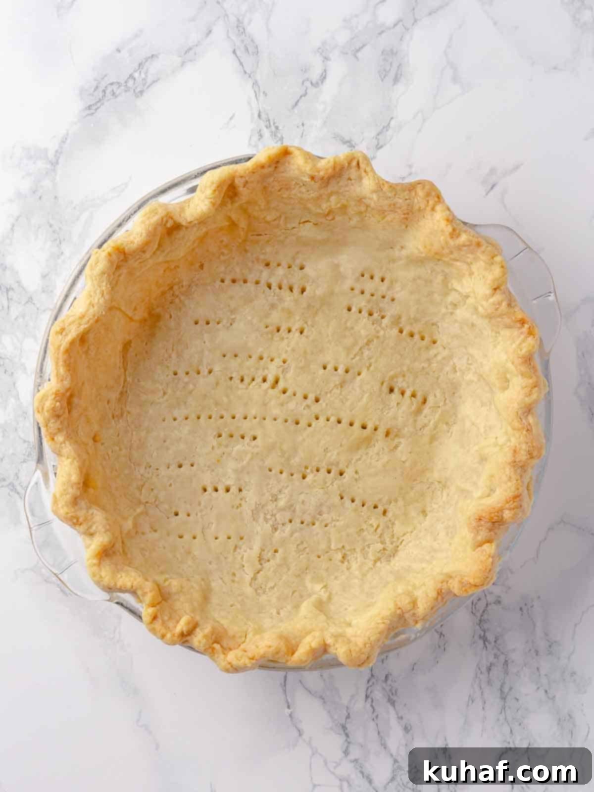 A perfectly blind-baked Pâte Sucrée crust, golden brown and docked, ready to be filled with a delicious tart filling.