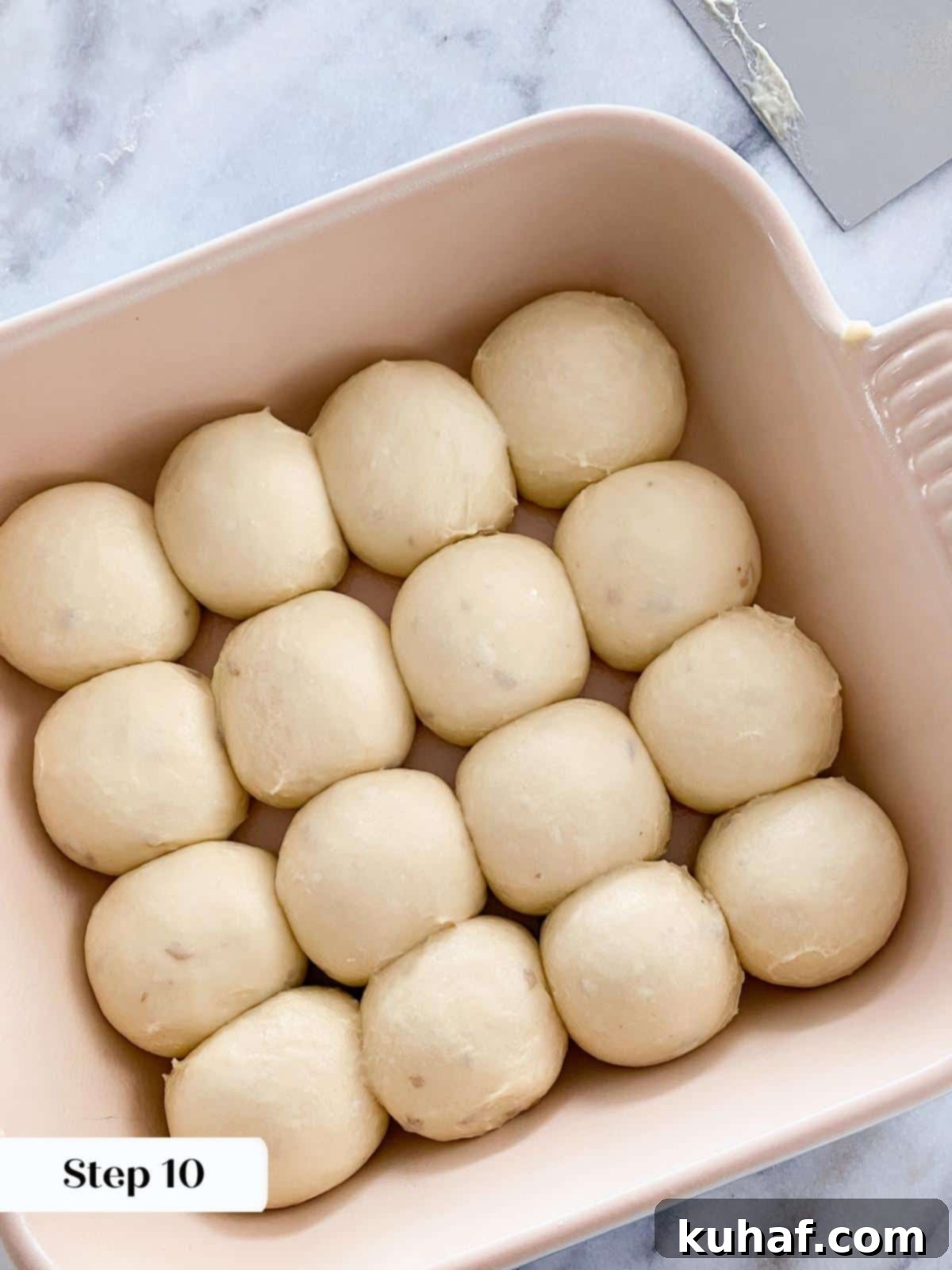 Pillowy Potato Rolls 4 Unproofed potato dough rolls arranged in a baking dish before rising.