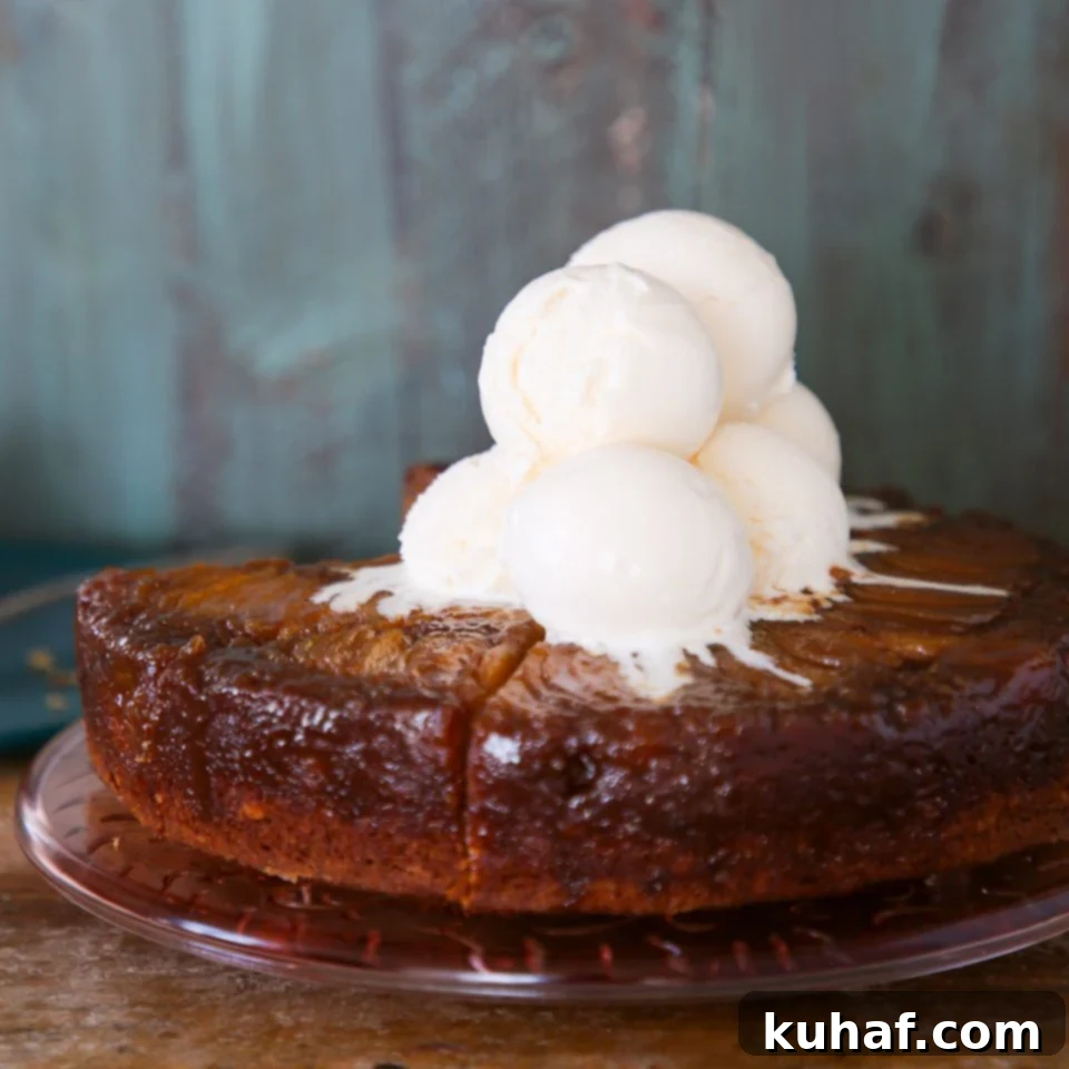 Pear upside down cake with scoops of vanilla ice cream on top, ready to serve.