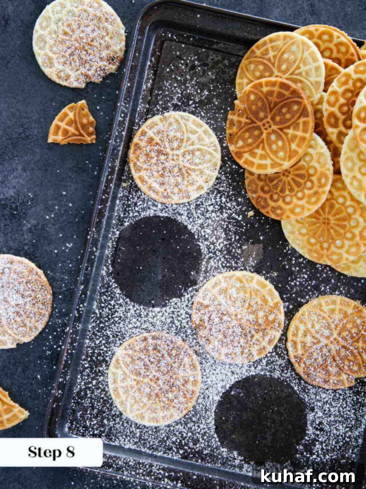 Cooked pizzelle, lightly dusted with powdered sugar, ready to serve.