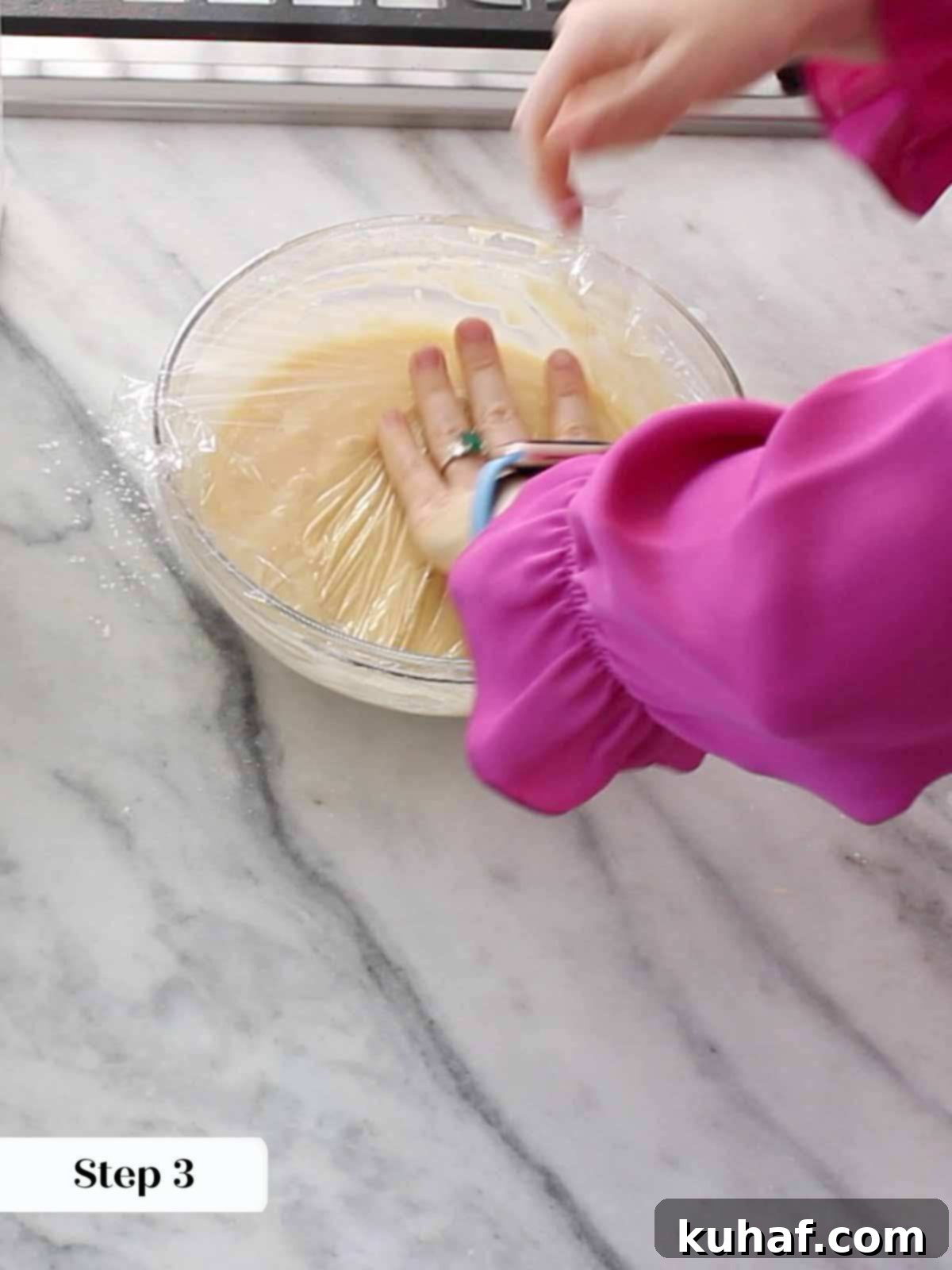 Pizzelle batter covered with plastic wrap, resting.