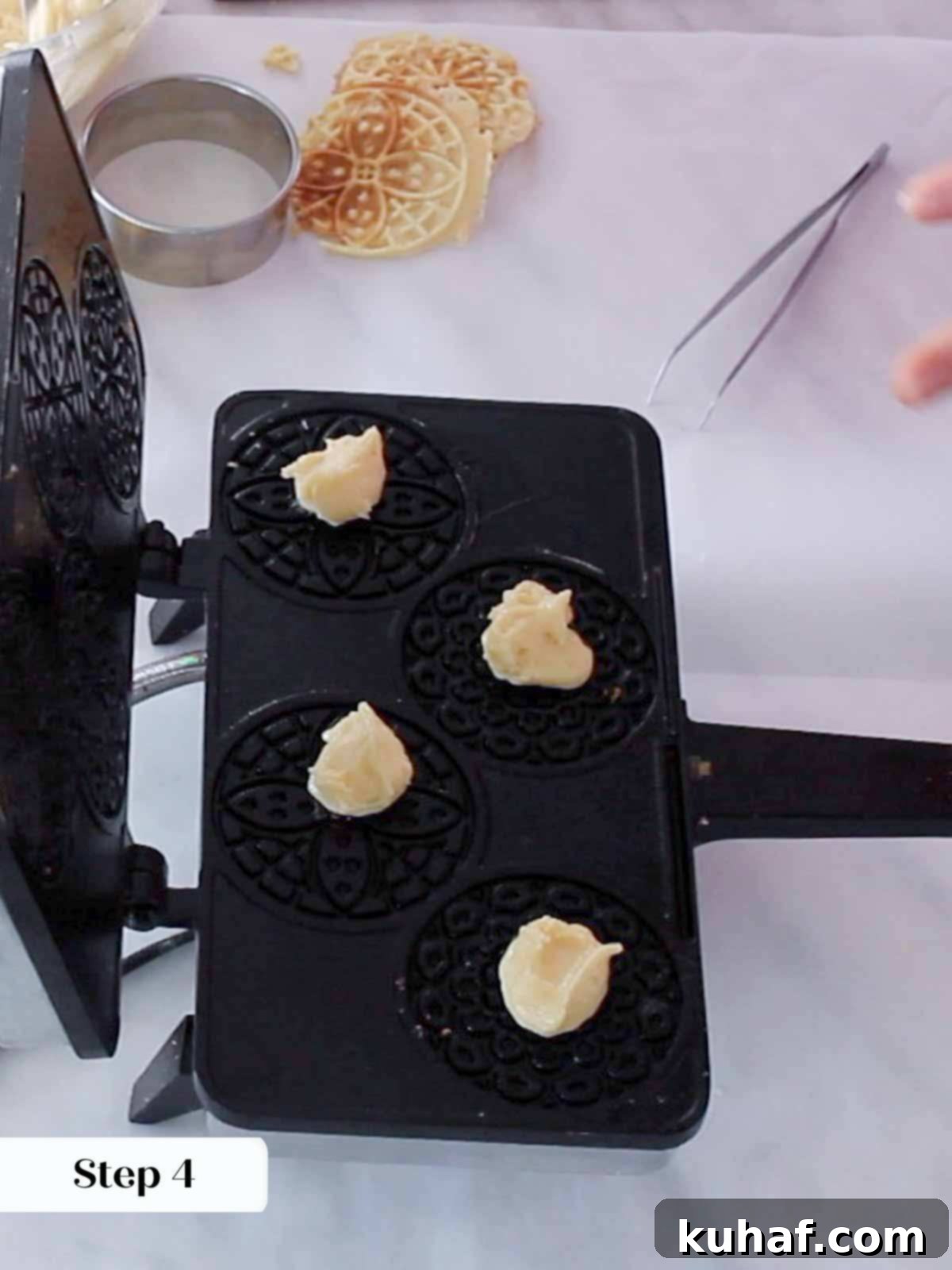 Dropping pizzelle batter onto a hot pizzelle press.