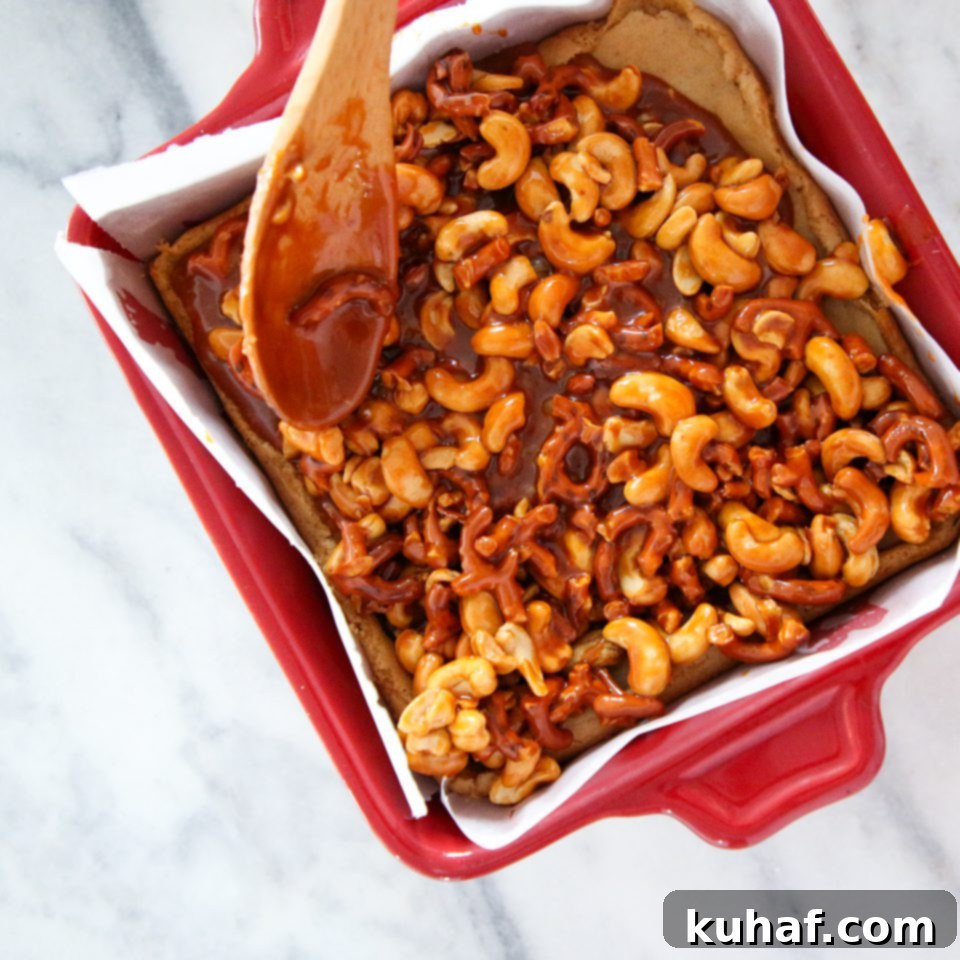 Cross-section of a Cashew Caramel Pretzel Blondie, showing the thick, chewy blondie base and generous topping.