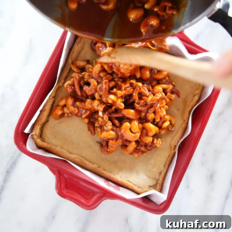 Close-up of the gooey caramel topping with roasted cashews and crushed pretzels.
