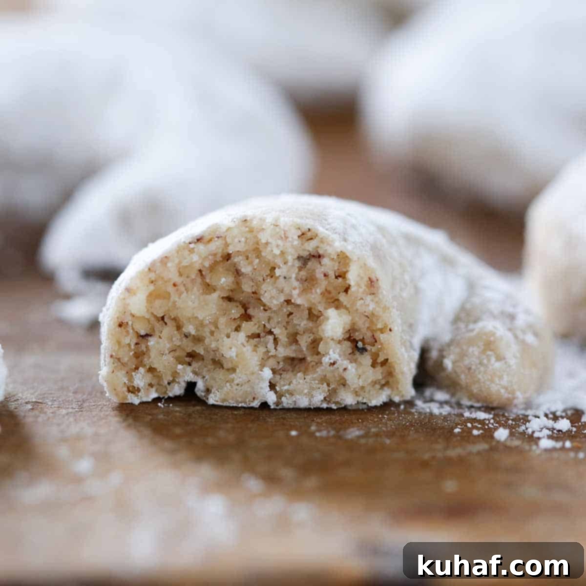 Interior texture of a crescent cookie, showing its crumbly, shortbread-like quality.