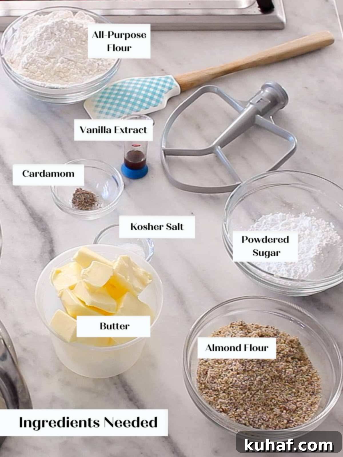 All ingredients for almond crescent cookies laid out on a marble surface.