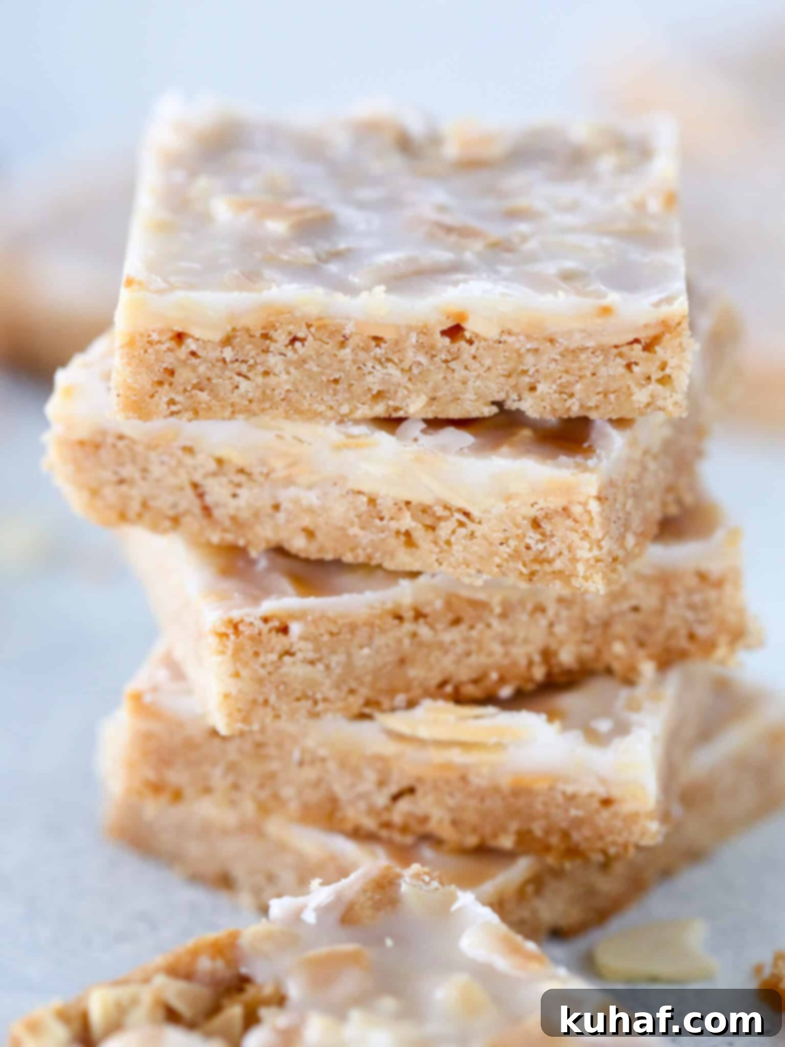 Crisp almond cookies stacked from the front, showing their golden brown color and glaze.
