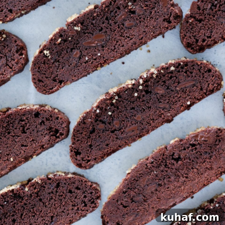 Perfectly sliced double chocolate biscotti arranged on a baking sheet, ready for their second bake to achieve ultimate crunch.