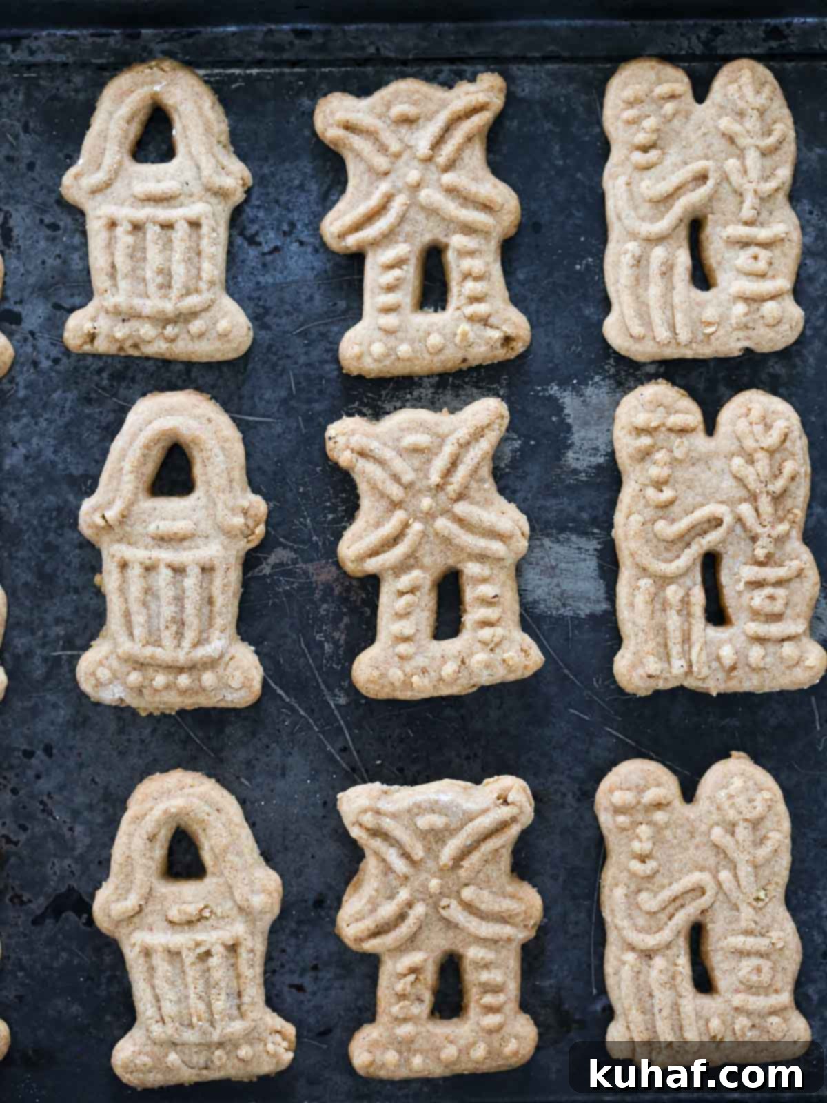 Beautifully detailed homemade Speculoos cookies, fresh from traditional molds, arranged on a rustic surface.
