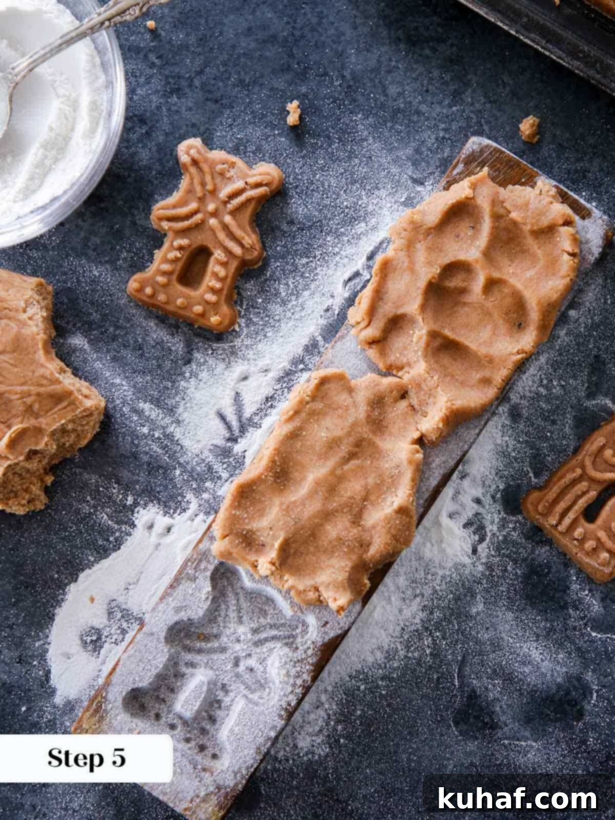 Chilled cookie dough pressed perfectly into a vintage wooden mold, showing the intricate design.