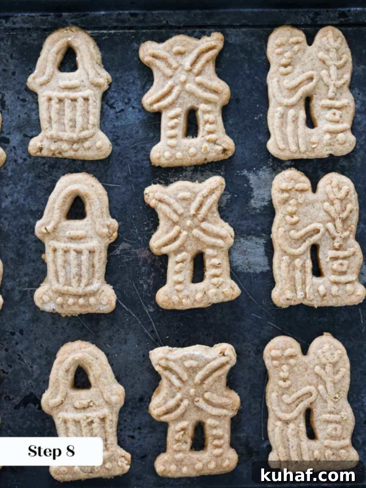 A batch of freshly baked, golden brown Speculoos cookies, with intricate patterns, resting on a cooling rack.