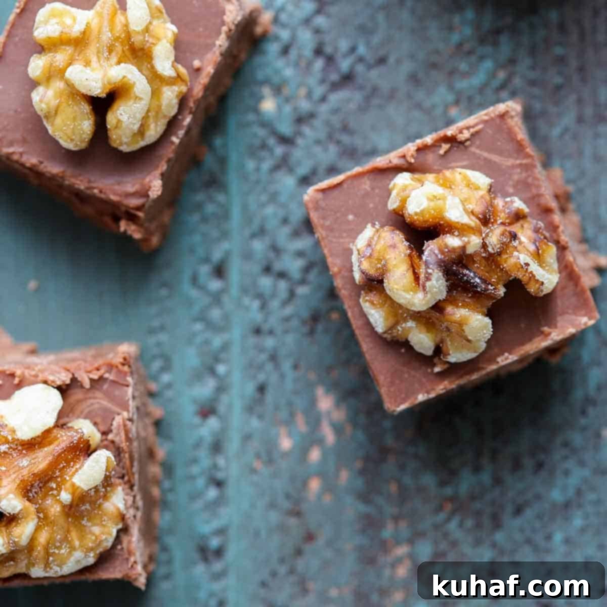3 pieces of fudge on teal wood surface.