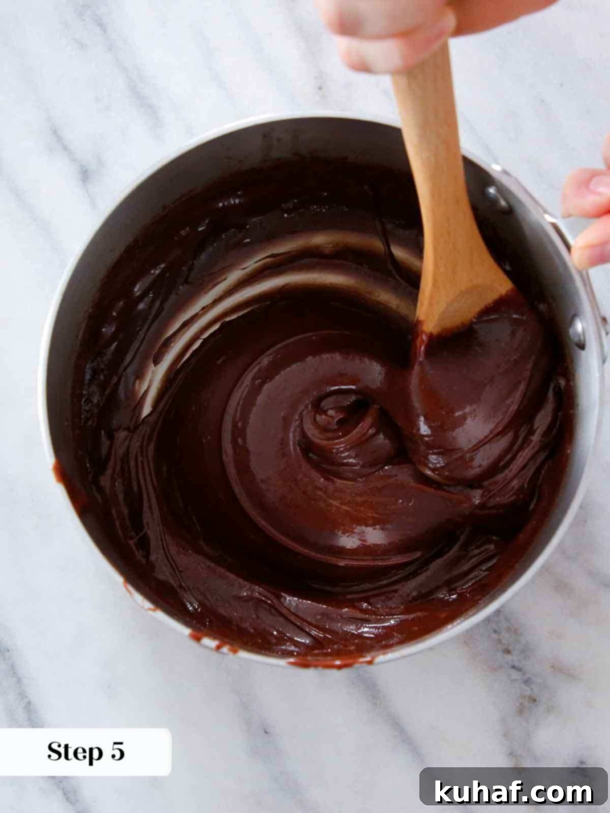 beating fudge in pot with wooden spoon.