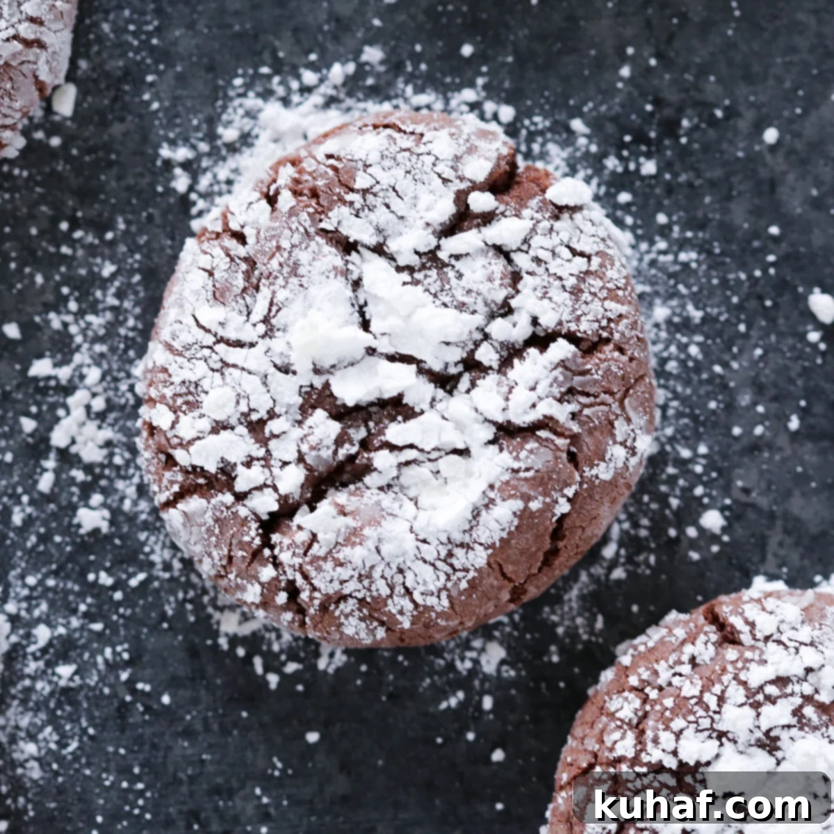 Chocolate Crackle Cookie with powdered sugar on black surface Easy Chocolate Desserts.
