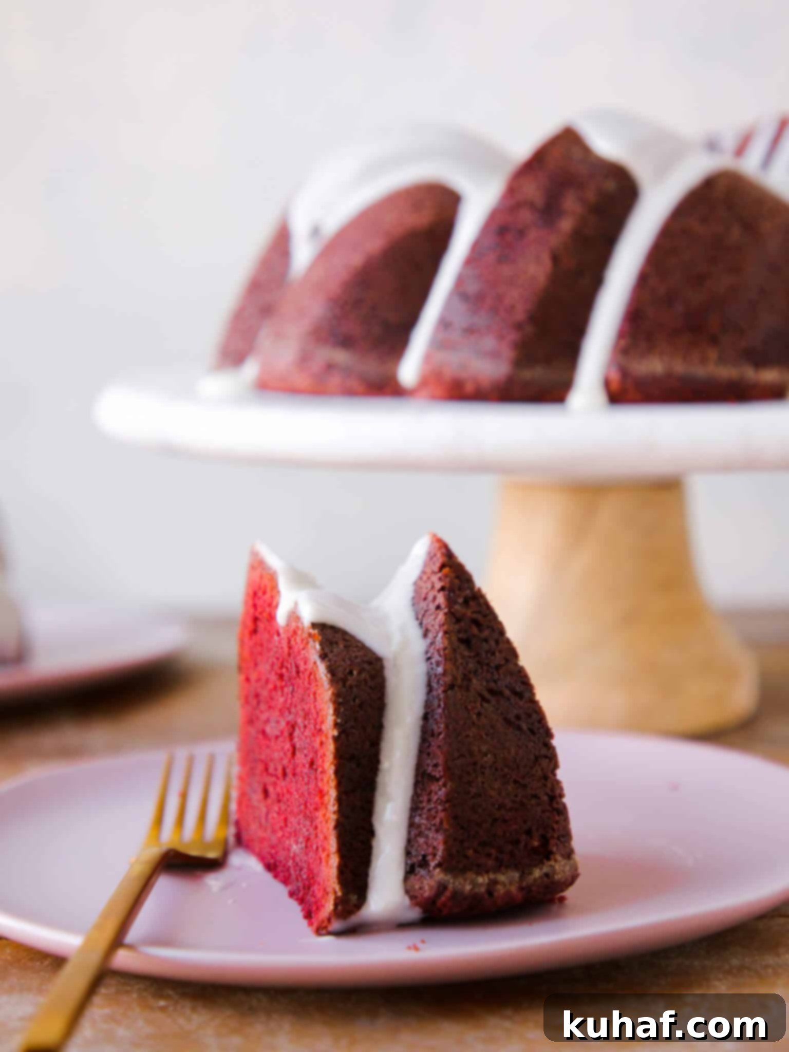 Red Velvet Pound Cake 2 Slice of Red Velvet Pound Cake with Cream Cheese Glaze, whole cake in background, perfect for Valentine's Day Desserts.