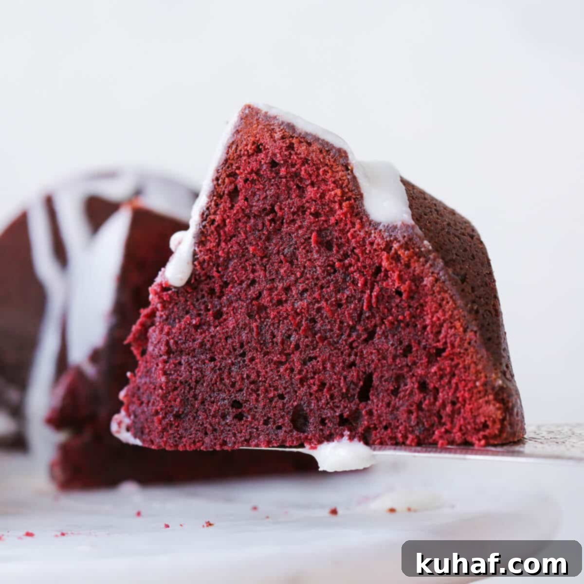 Red Velvet Pound Cake 3 Slice of Red Velvet Pound Cake with Cream Cheese Glaze on a cake server, ready to be enjoyed.