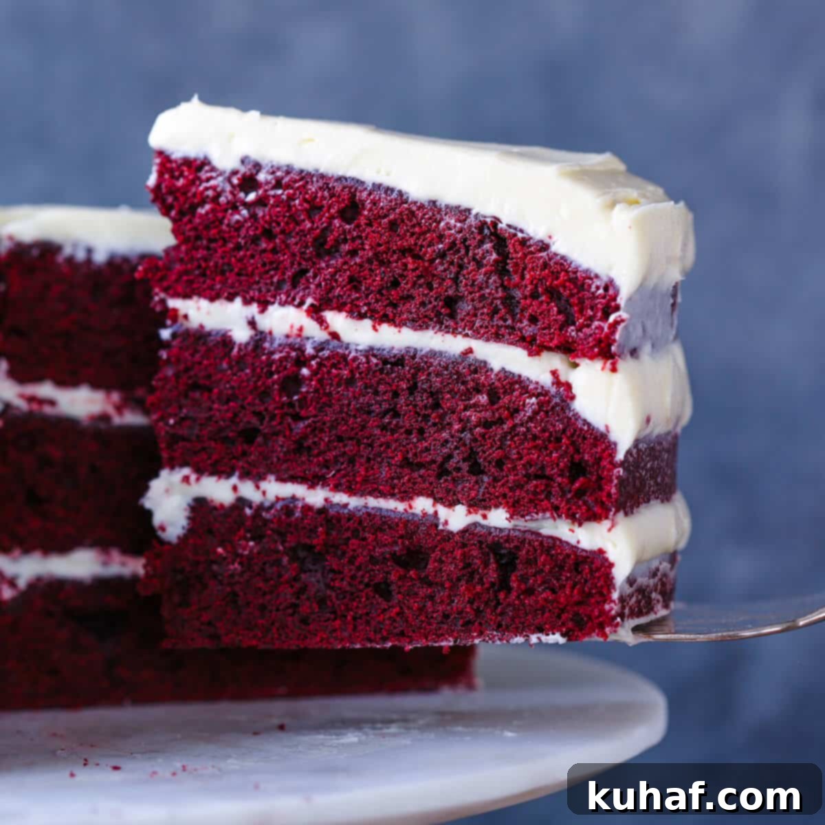 Flawless Red Velvet Cake Every Time 3 Red Velvet Layer Cake Cream Cheese Buttercream slice on cake server, showcasing the layers and smooth frosting.
