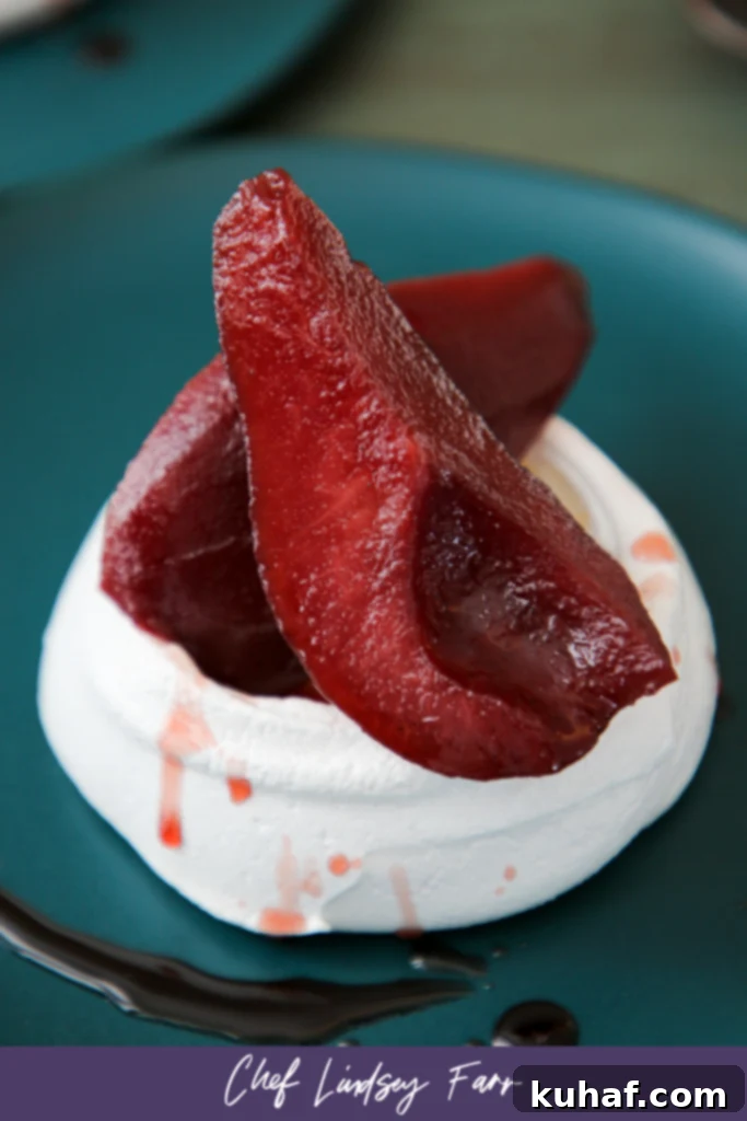 Poached Pear Pavlova served on a plate with a spoon, highlighting its inviting texture.