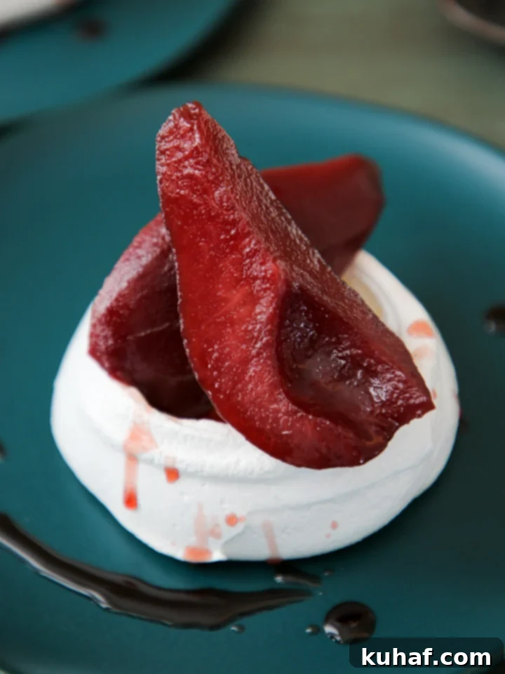 Multiple Poached Pear Pavlovas cooling on a wire rack.