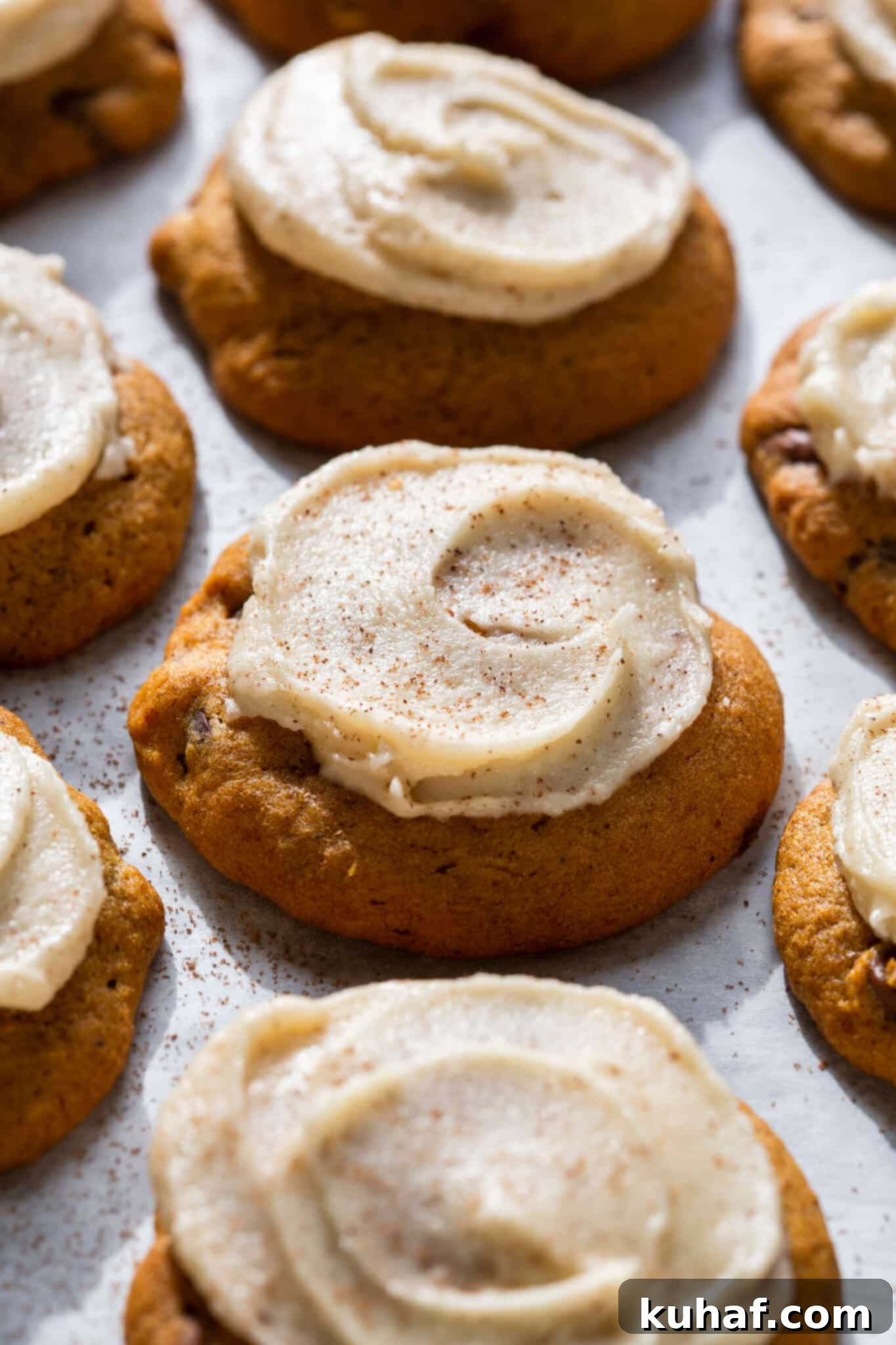 Spiced Pumpkin Chocolate Delights 2 Chewy chocolate chip pumpkin cookies with browned butter icing close up, showing the soft texture and generous chocolate chips.