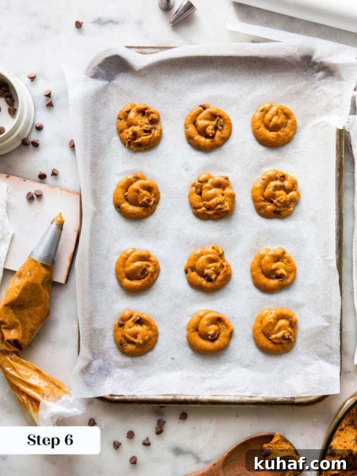 Spiced Pumpkin Chocolate Delights 8 Uniform pumpkin chocolate chip cookie dough portions piped onto a baking sheet, ready for the oven.