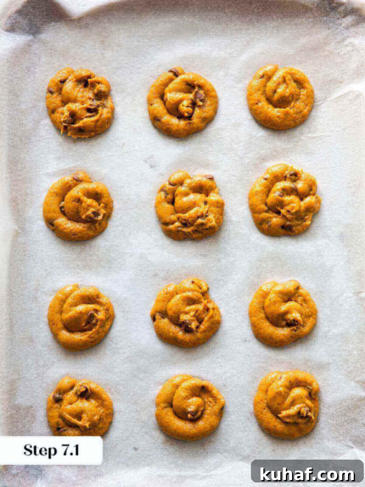Spiced Pumpkin Chocolate Delights 9 Cookie dough balls of pumpkin chocolate chip cookies evenly spaced on a baking sheet, ready for baking.