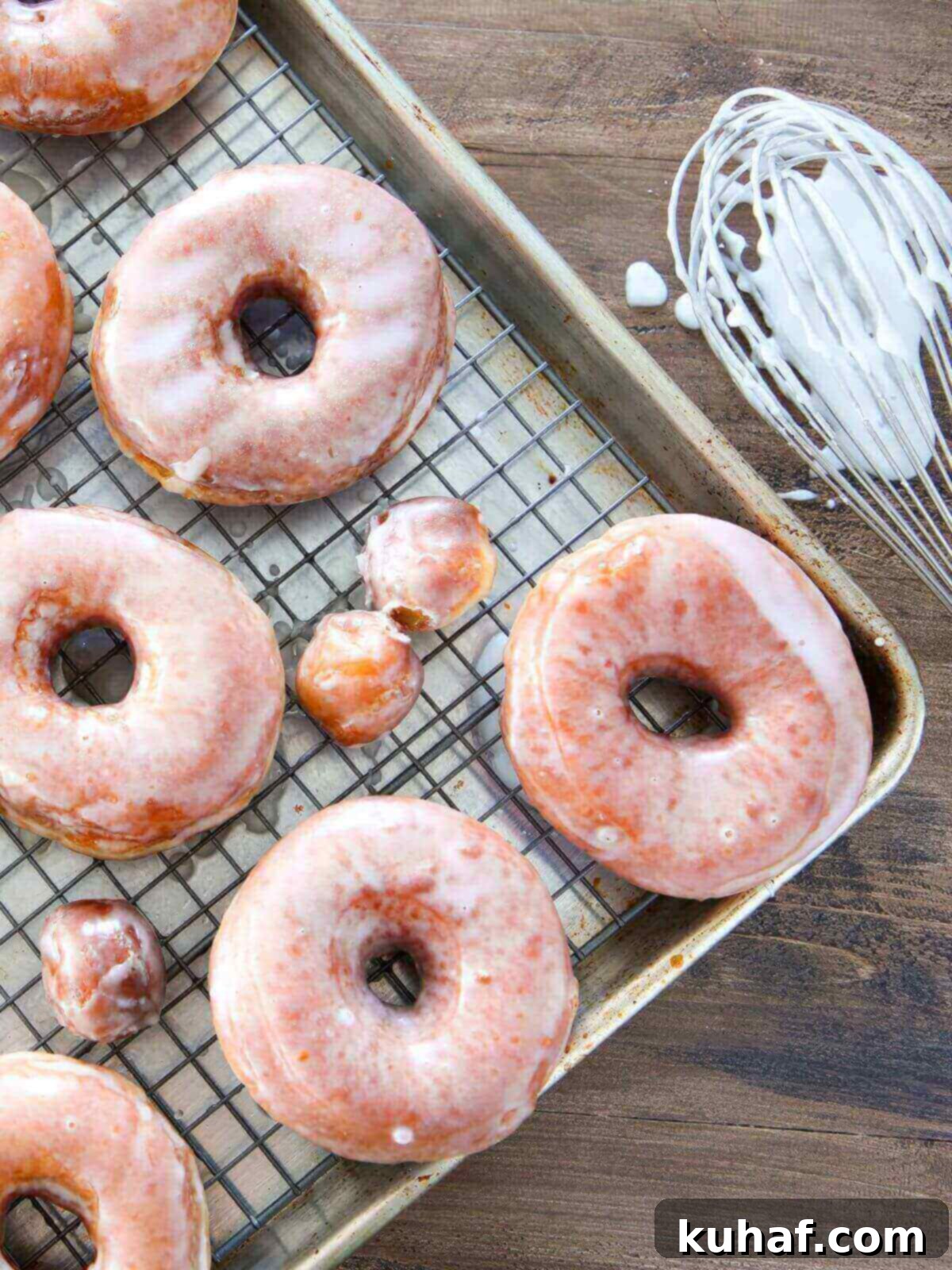 A close-up of perfectly glazed Krispy Kreme donuts, shining under the light.