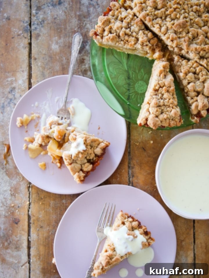 Slice of Caramel Apple Tart on a rustic wood surface, revealing layers of apple and caramel.