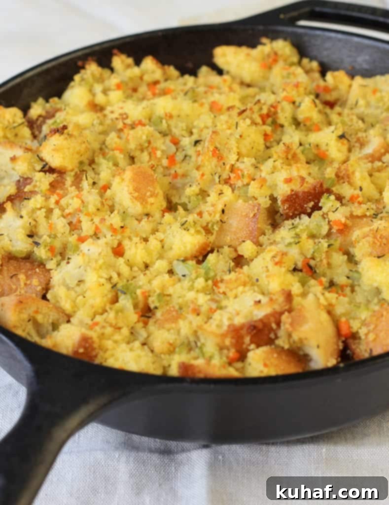 A spoon scooping out a serving of Classic Cornbread Stuffing from a large baking dish.