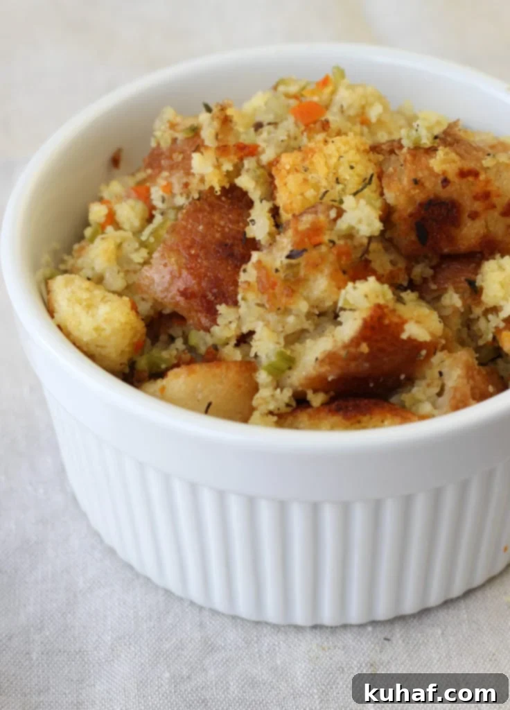 Individual ramekin of Classic Cornbread Stuffing garnished with fresh herbs.